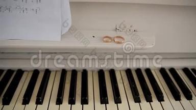 两个结婚戒指在<strong>钢琴</strong>和旧音乐音符上